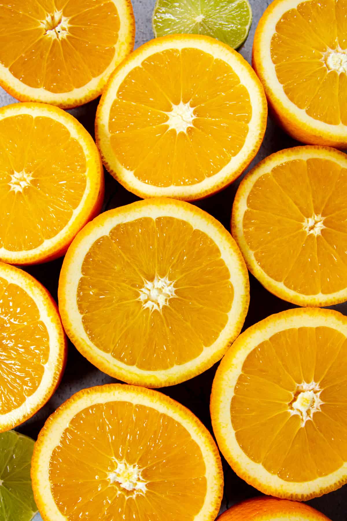 A close up of oranges and limes cut in half.