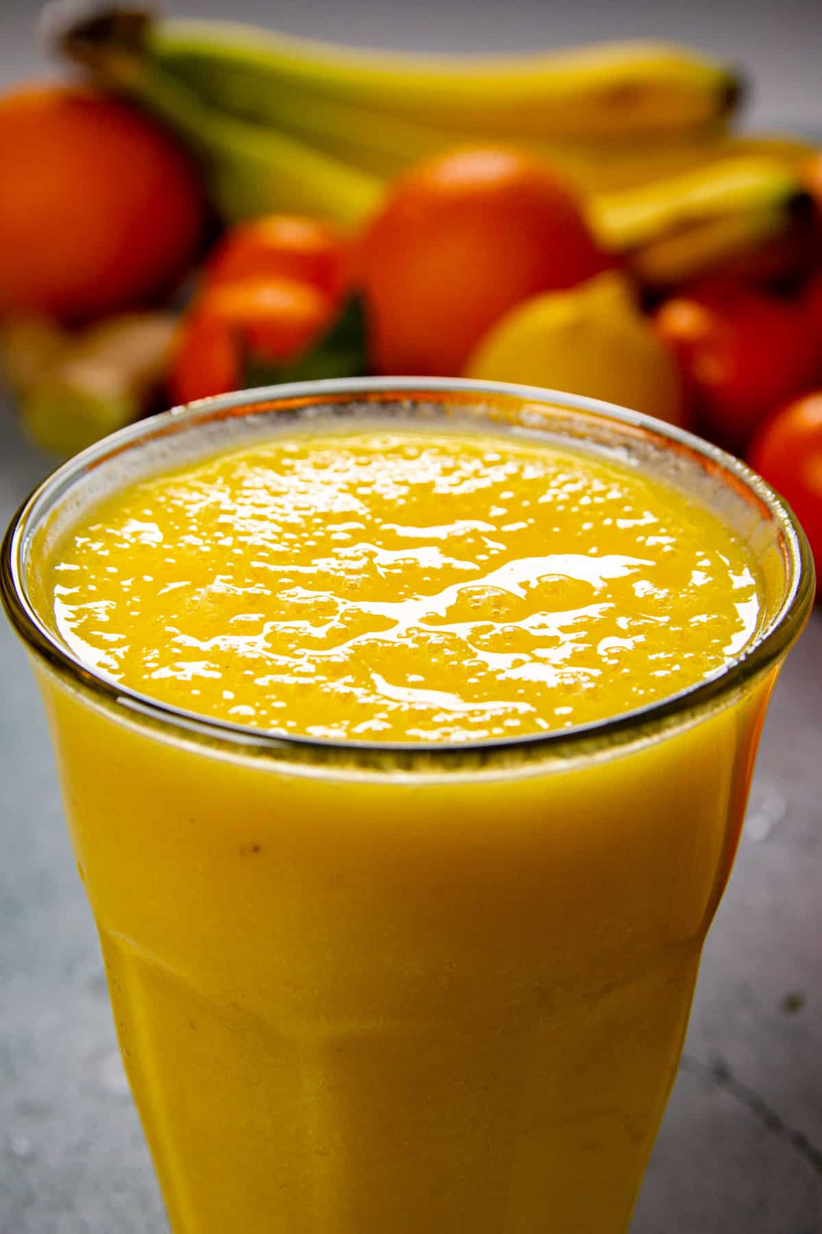 A close up of the banana mango smoothie in a tall glass.