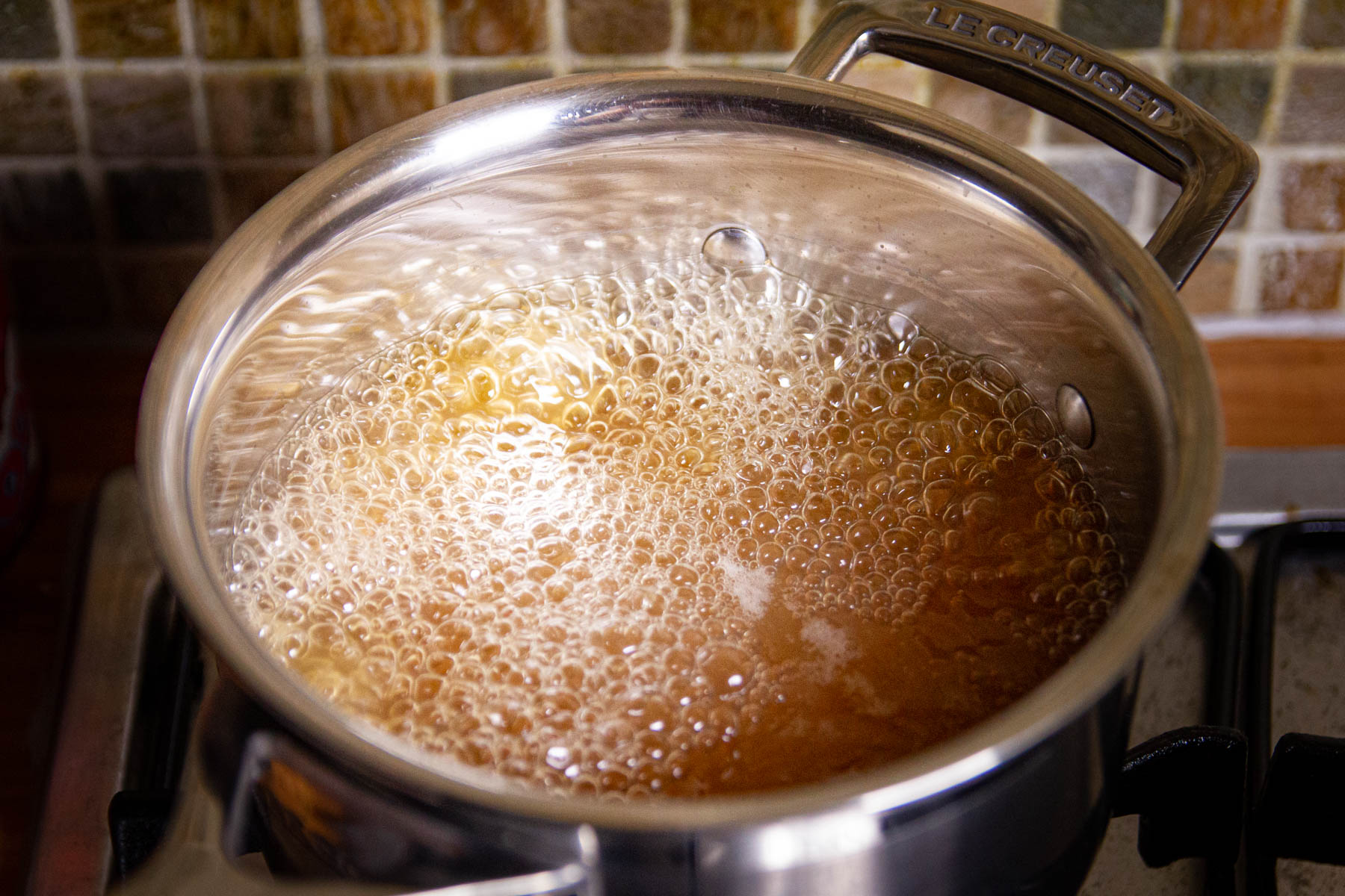 Boiling the chicken stock in a pot.