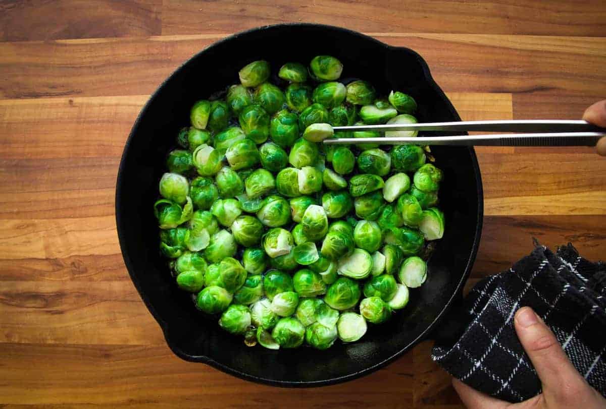 Searing the brussel sprouts in hot oil.