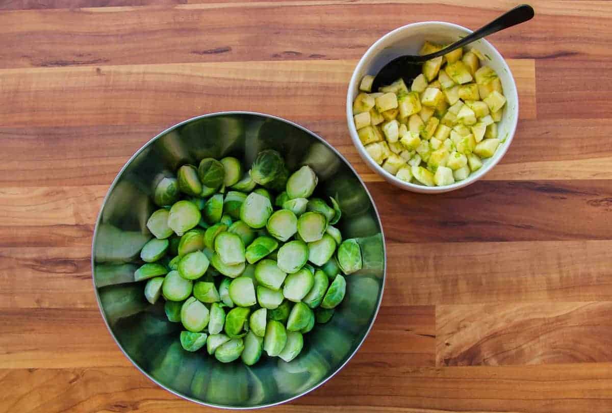 The cut brussel sprouts in one bowl and the banana and lime in another bowl.