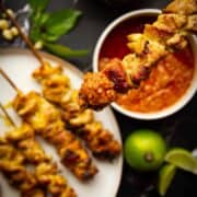 Charcoal chicken satays dipped in peanut sauce.