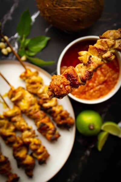 Charcoal chicken satays dipped in peanut sauce.