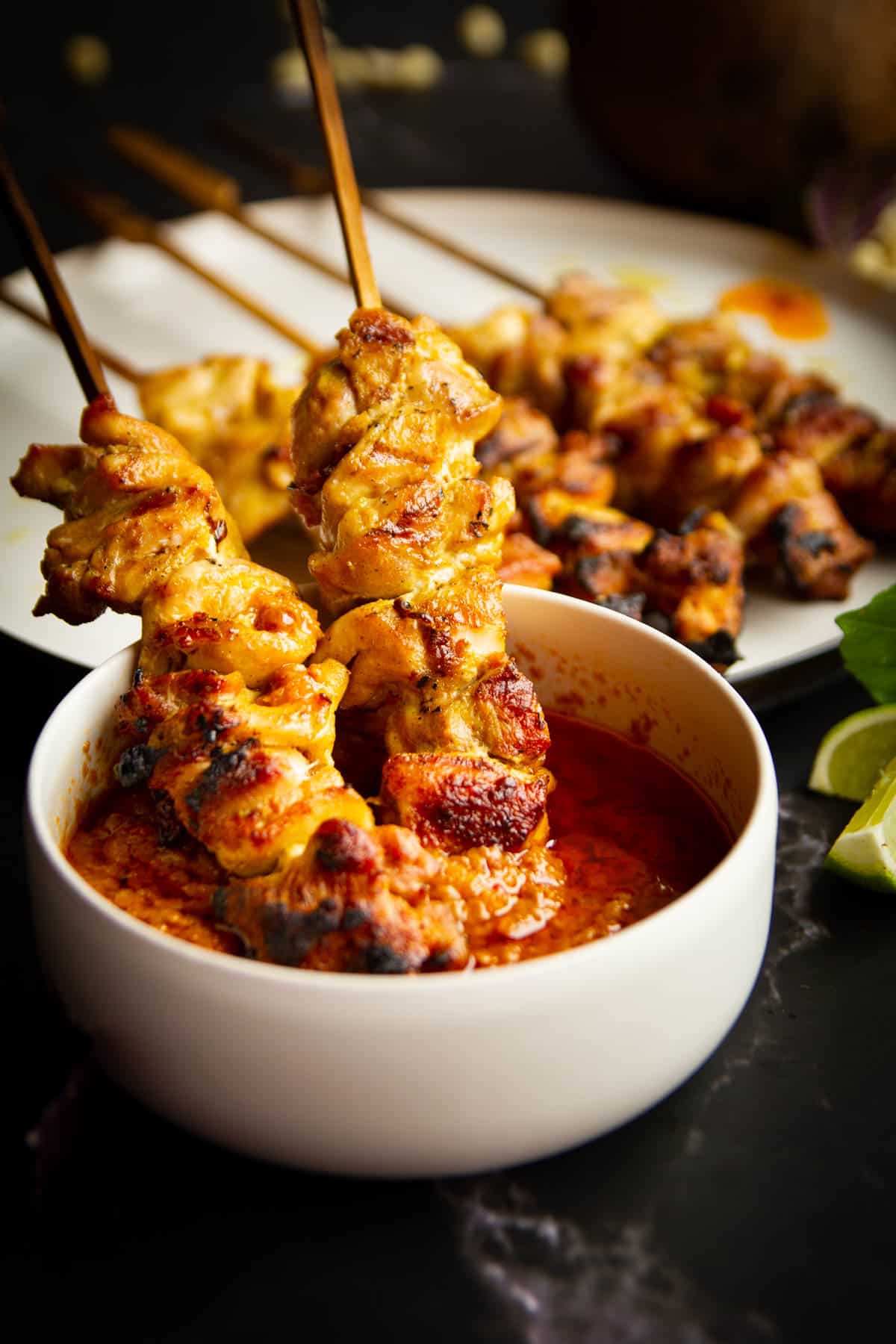 Charcoal chicken satays dipped in peanut sauce.