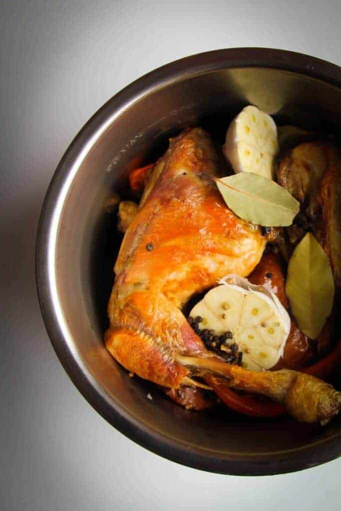 Roasted chicken bones and vegetables in the instant pot ready to be made into stock.