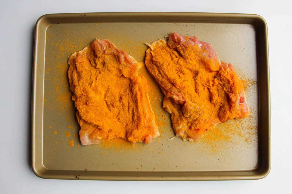 Marinating the chicken in curry powder on the flesh side.