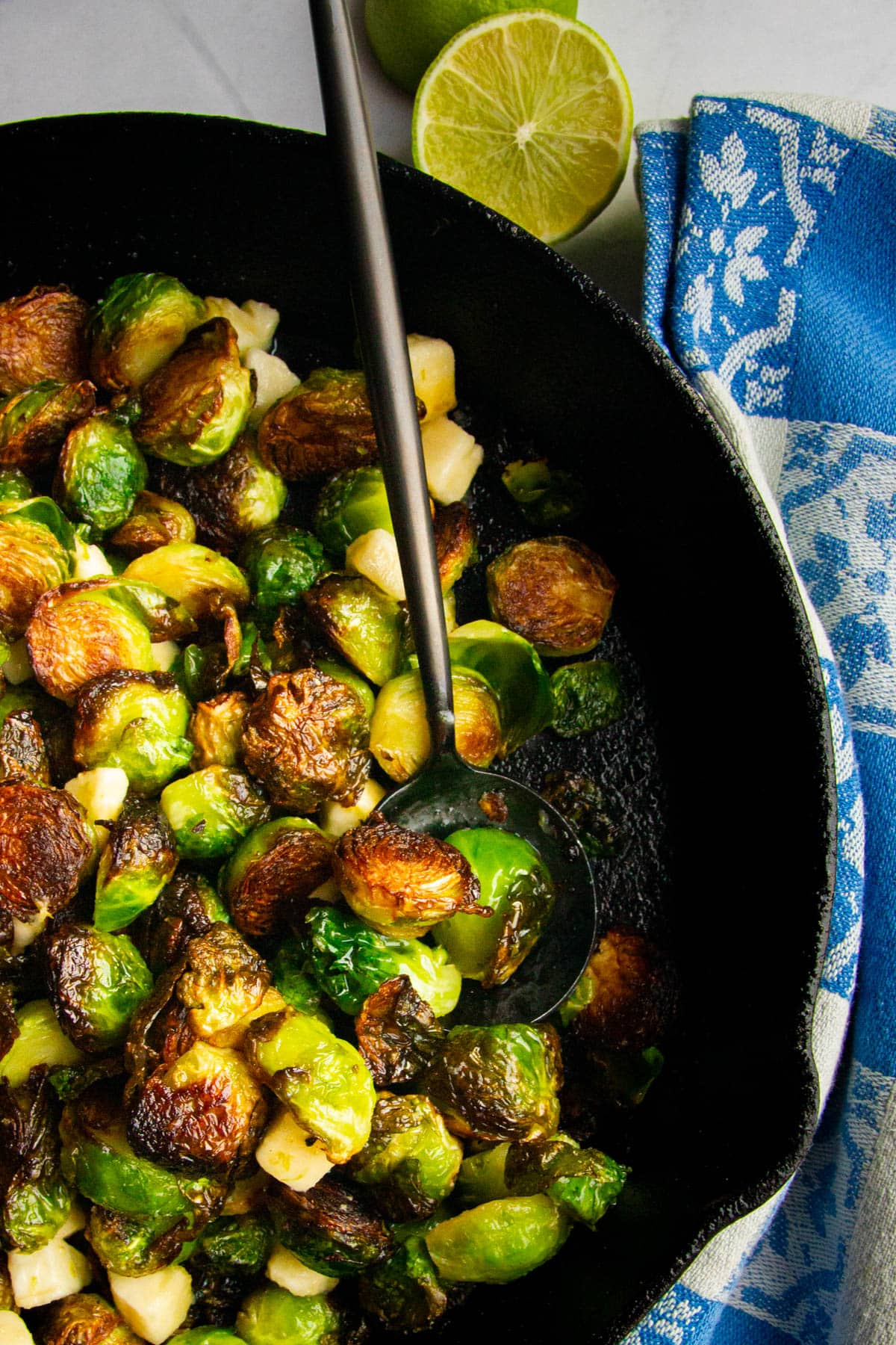 A spoon in the pan of the crispy roasted brussel sprouts.