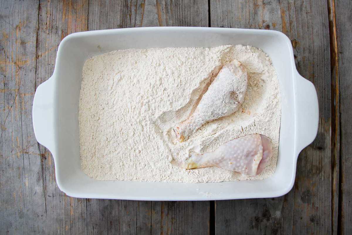 Dredging the chicken in the seasoned flour.