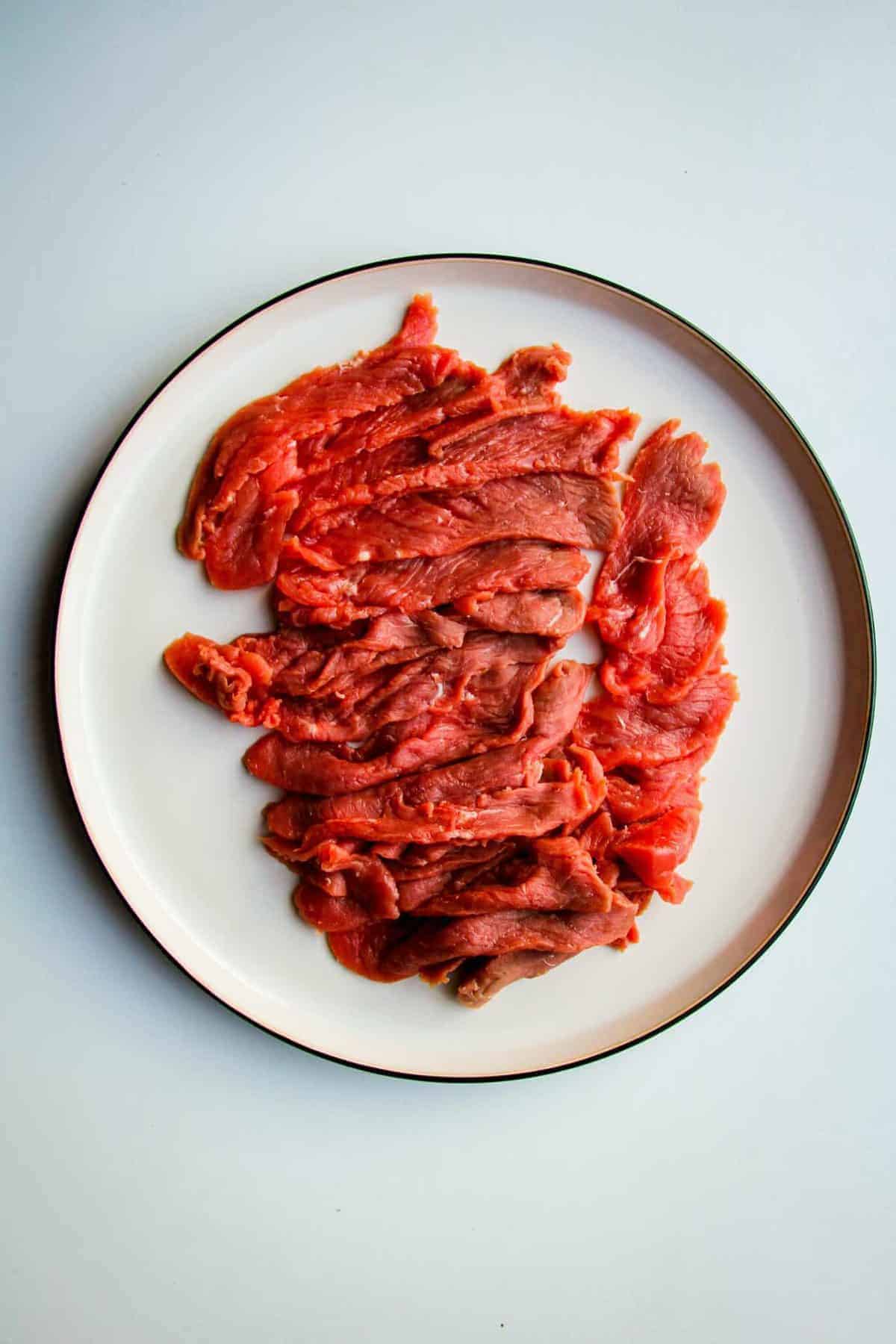 Thinly sliced raw beef on a plate.