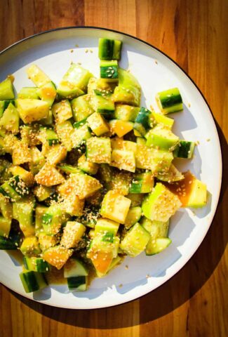 Crunchy apple cucumber salad with miso and sesame on a plate.