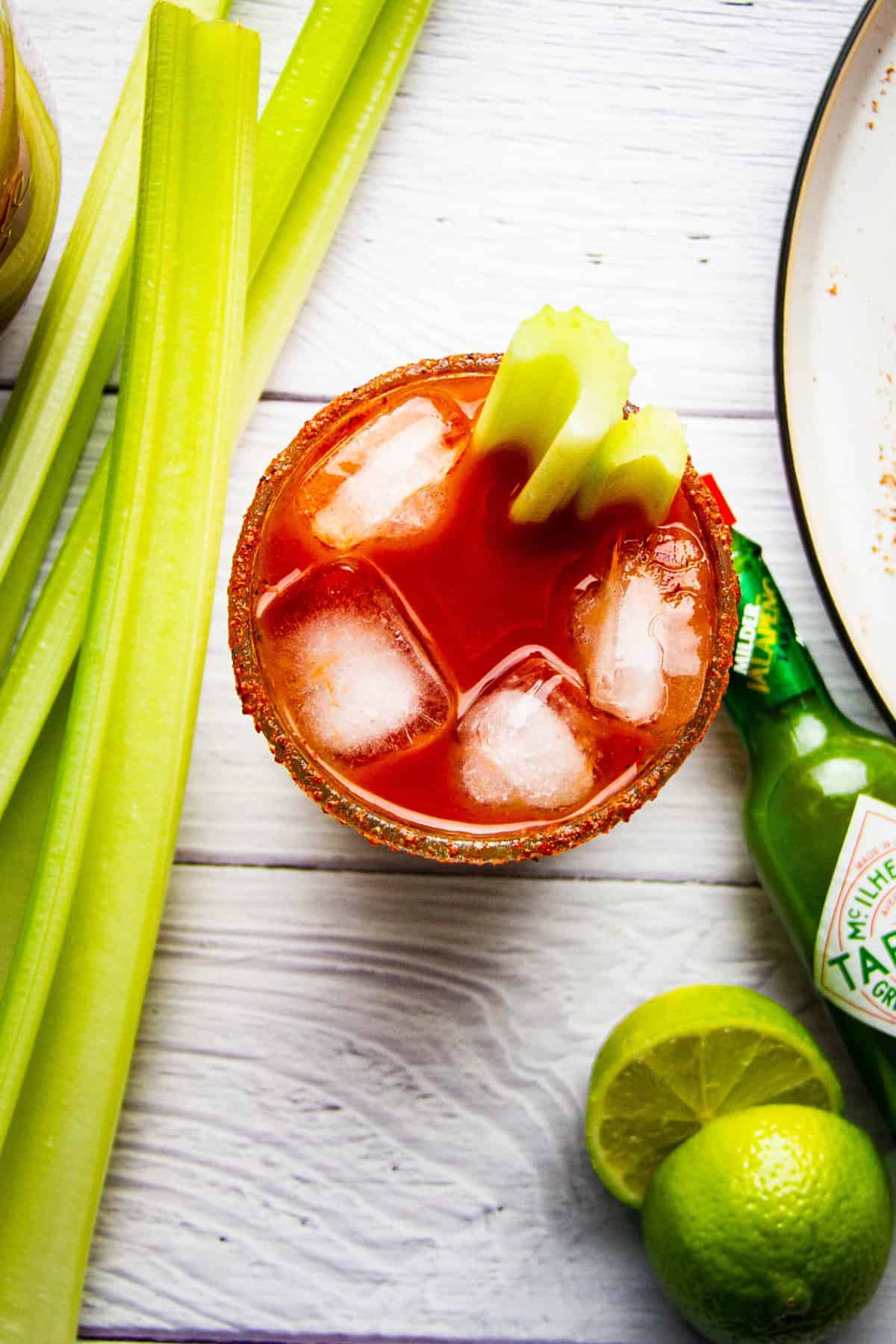 A bbq bloody mary cocktail with celery and lime.