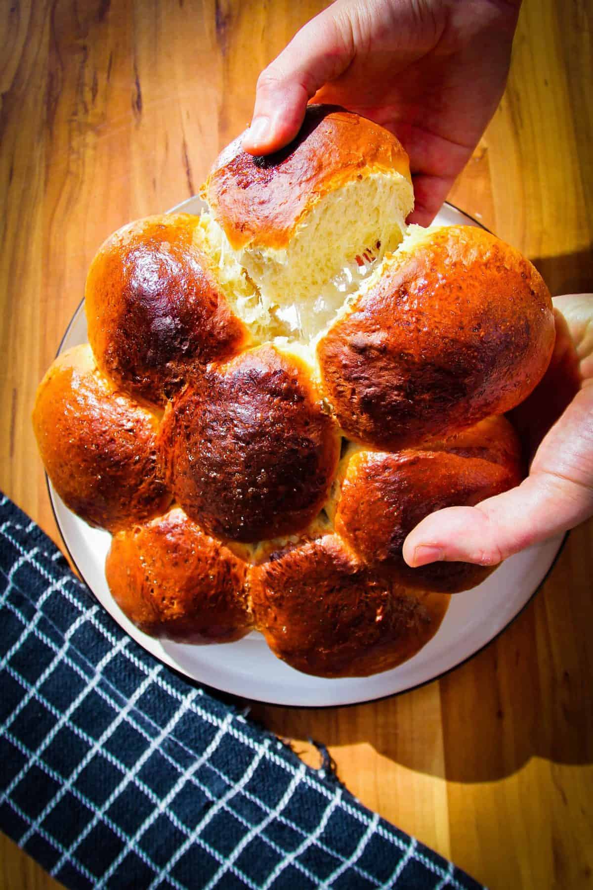 A pull-apart dinner roll being pulled apart.