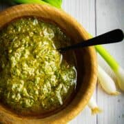 Green onion chimichurri in a bowl with green onions on the side.