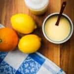 lemon vinaigrette in a bowl with some lemons and oranges.