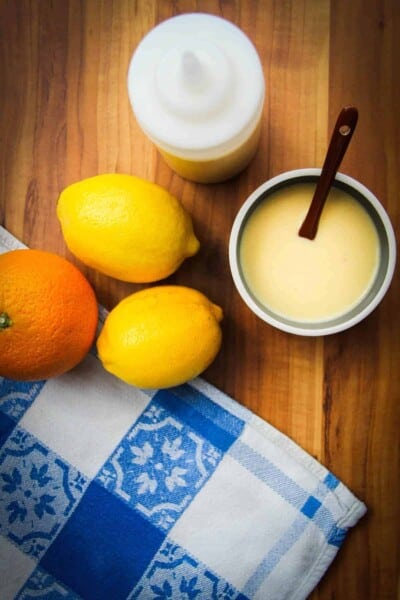 lemon vinaigrette in a bowl with some lemons and oranges.