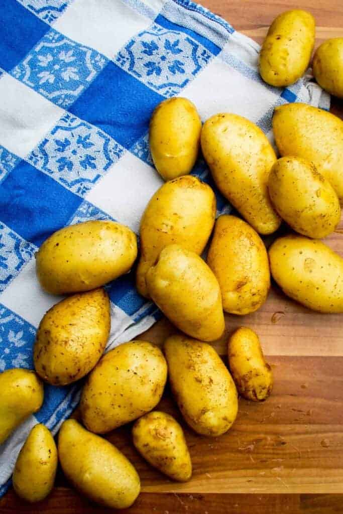 Raw new potatoes on a board.