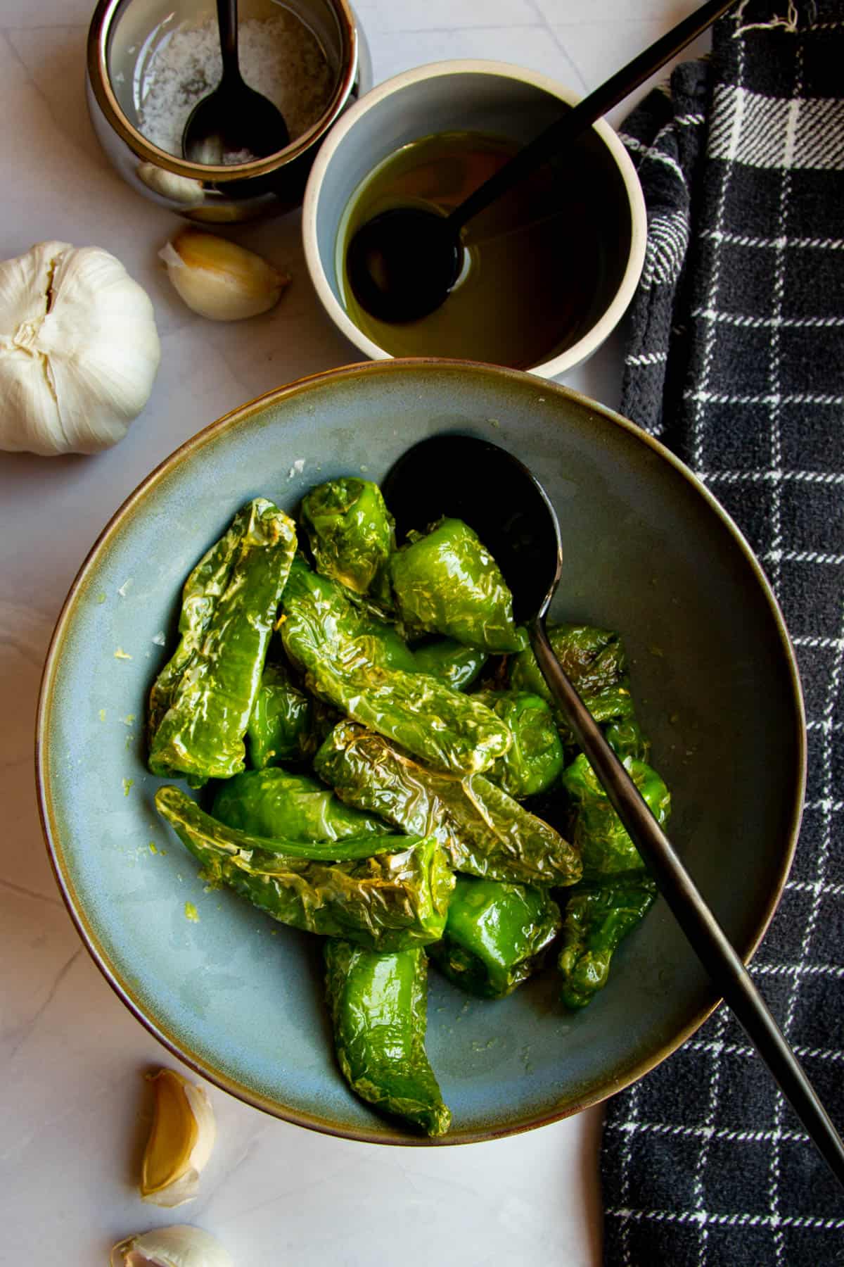 Padron peppers in a bowl with ginger garlic and lime zest.