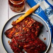 Fall off the bone ribs on a plate with a brush and some bbq sauce.