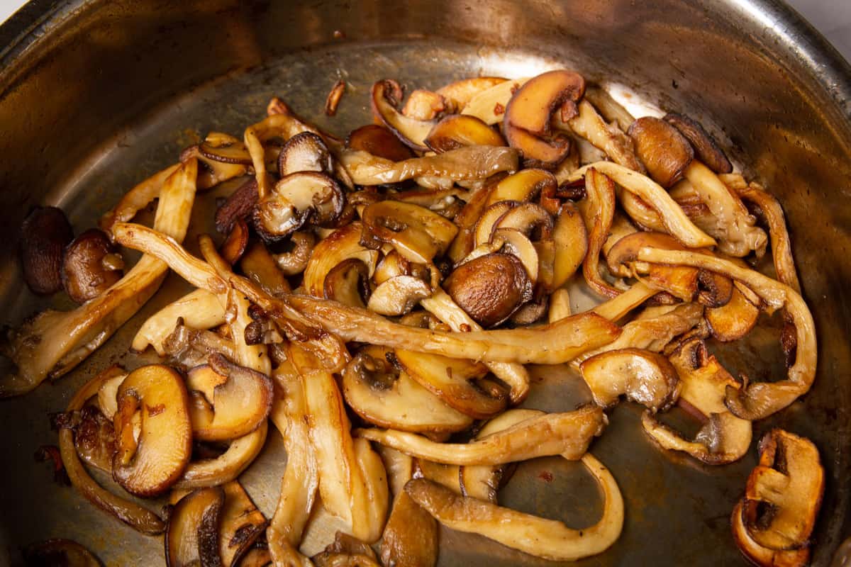 The browned mushrooms in a pan.