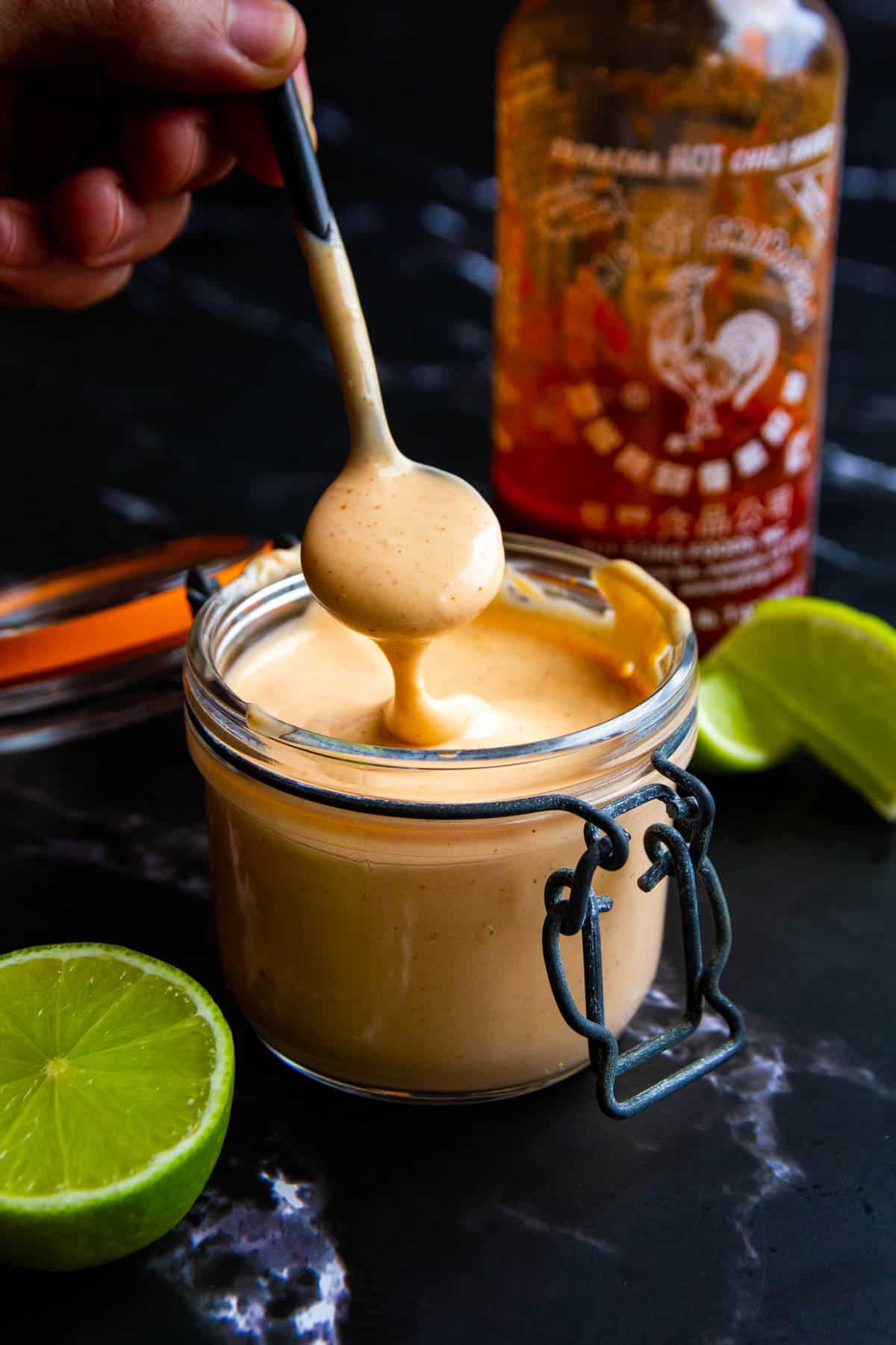 Spicy mayo in a small mason jar with a spoon.