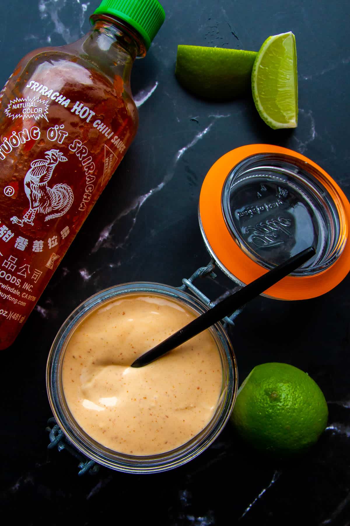 Spicy mayo in a small mason jar with a spoon.