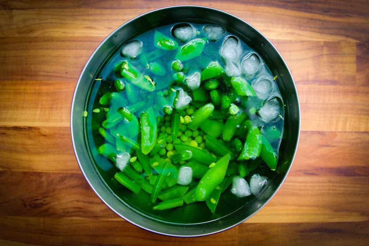 Refreshing the peas in ice water.