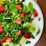 Strawberry pea and basil salad on a plate.