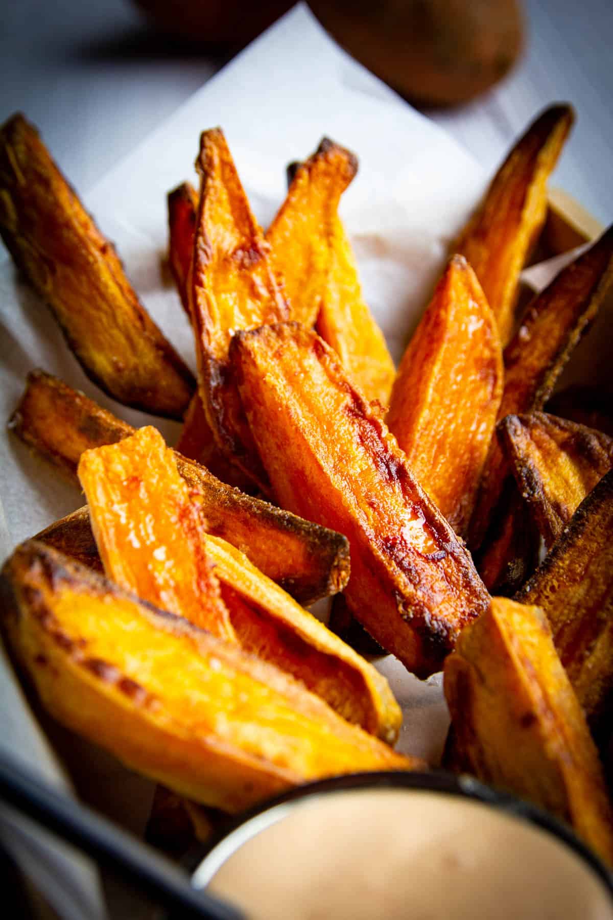 Crispy sweet potato wedges with spicy mayo on the side.