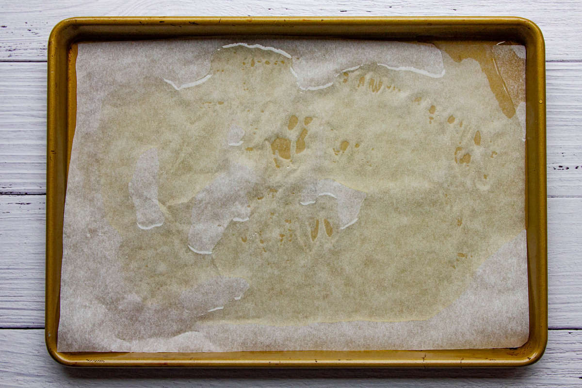 The oiled baking tray with parchment paper.