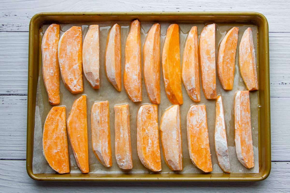 The dusted sweet potato wedges on a tray.