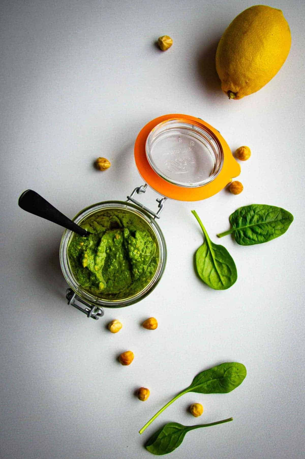Vegan pesto in a jar with hazelnuts, lemon and spinach.