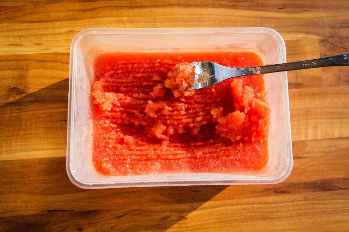 Scraping the watermelon granita with a fork.