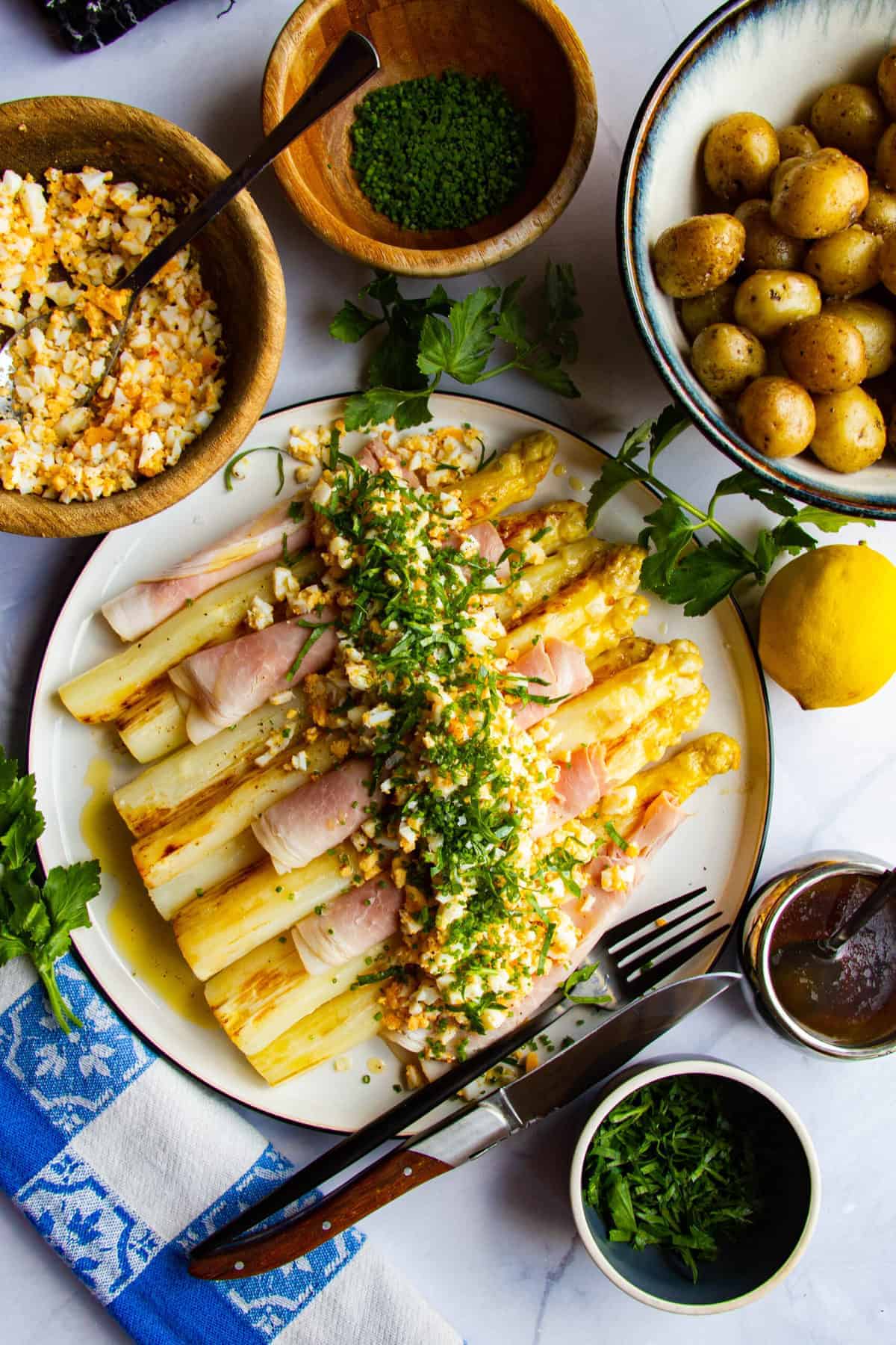 White asparagus with ham, egg, potato, chives, parsley and brown butter.