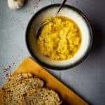 zucchini dip in a bowl with fresh bread on the side.