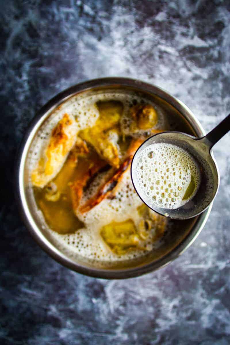 Skimming the broth before cooking the stock.