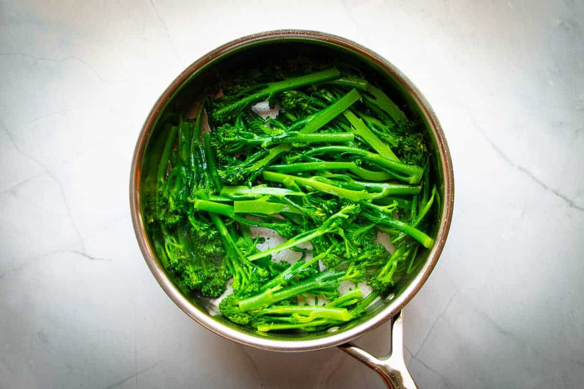 Quickly cooking the broccolette in the pan.