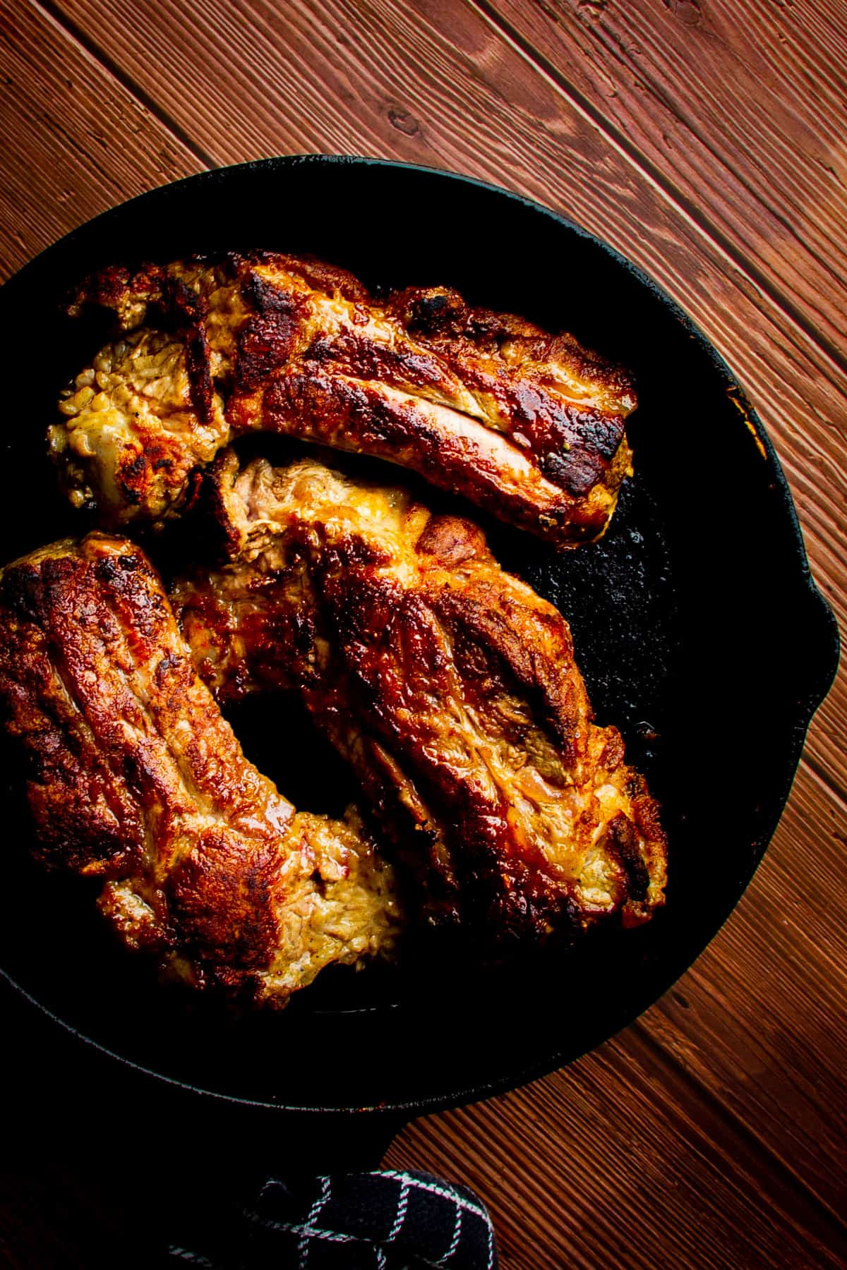 The seared short rib in a cast iron pan.