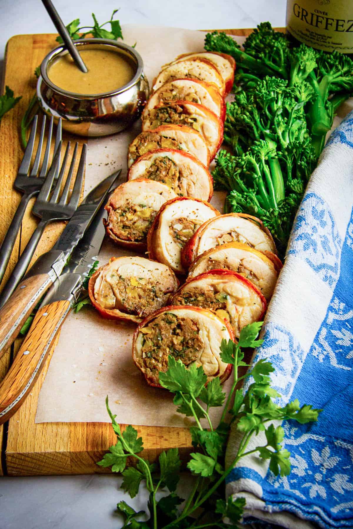 A close up of a stuffed chicken leg sliced on a board.