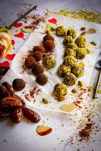 Rolled vegan chocolates in pistachio and cocoa powder.