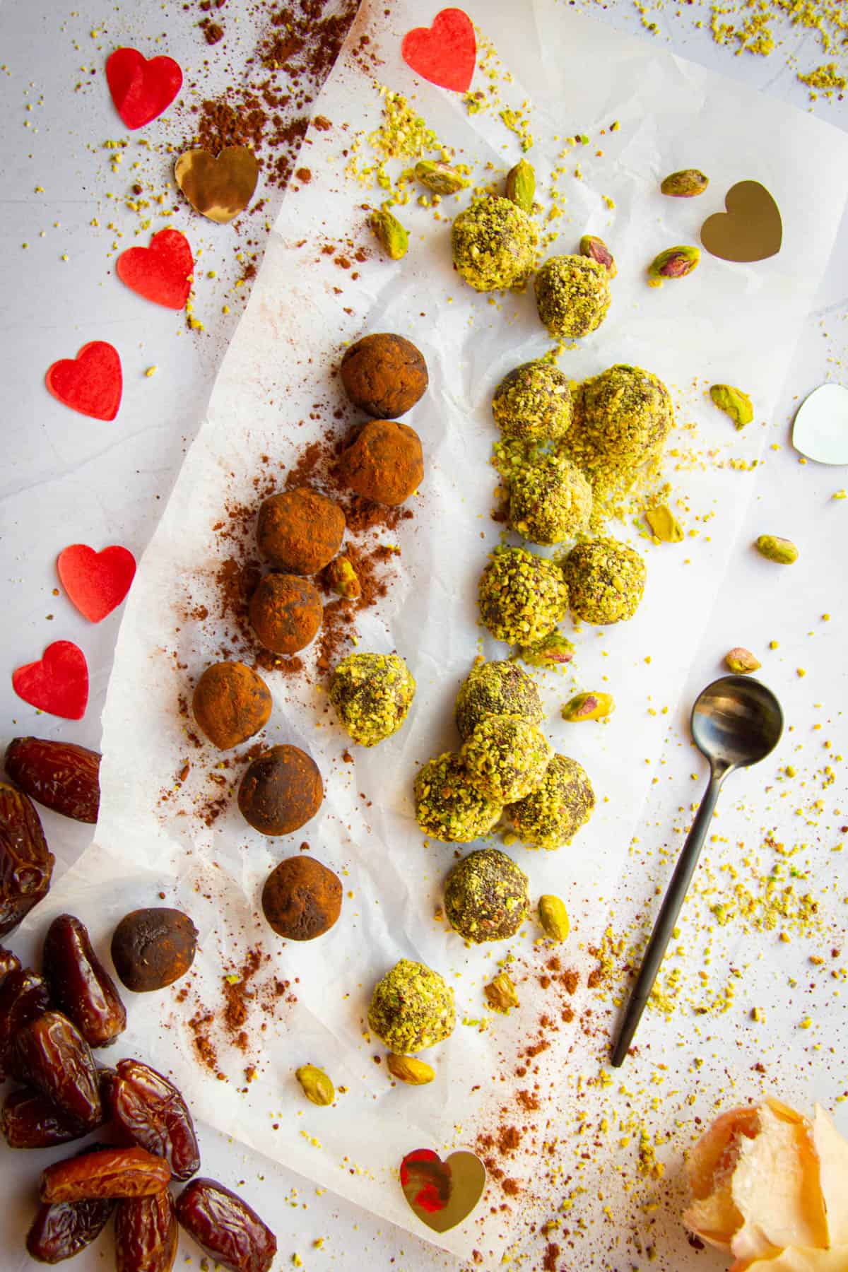 Vegan chocolate truffles lying on a table with hearts around.