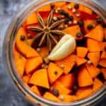 Fermented carrots in a mason jar with spices.