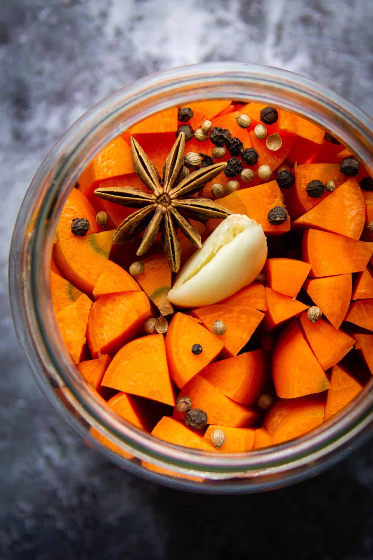 Fermented carrots in a mason jar with spices.