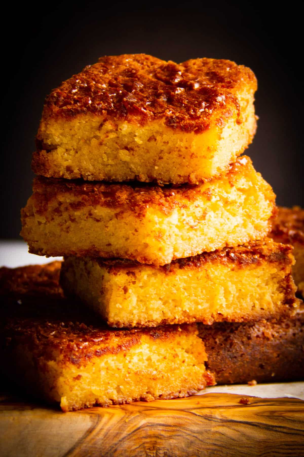 Vanilla Brownies aka blondies stacked on a board.