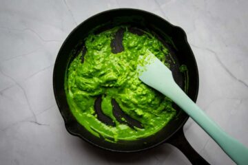 Mixing the green eggs in a cast iron skillet pan.