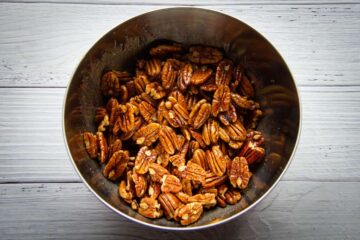 tossing the pecans in butter, chili, cinnamon and salt