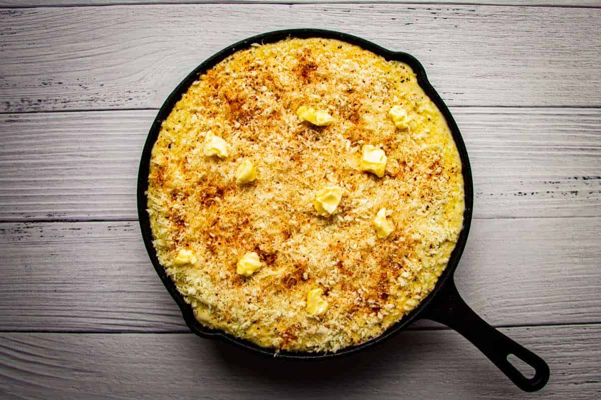 mac and cheese in a pan with panko, bbq spice and butter on top.