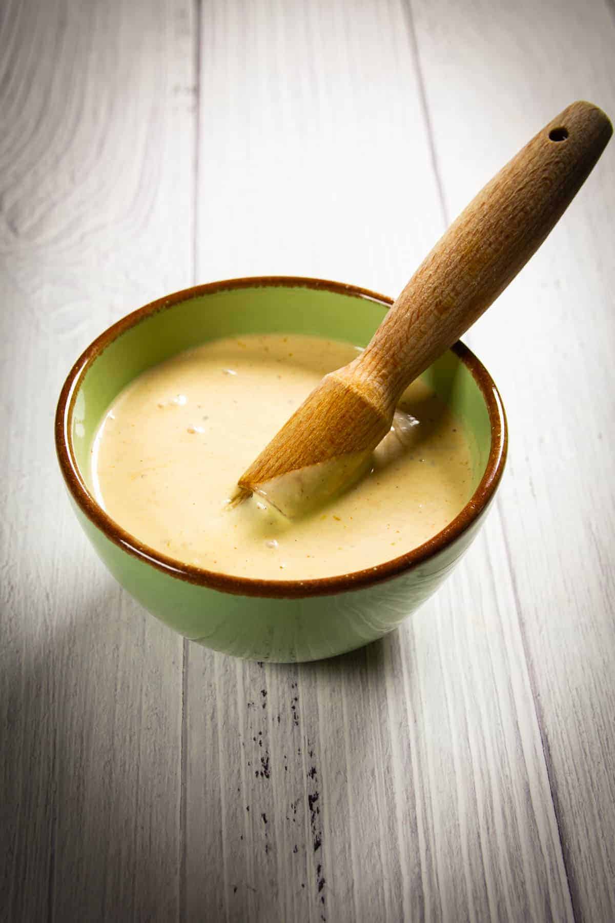 Alabama white bbq sauce in a bowl with a brush.