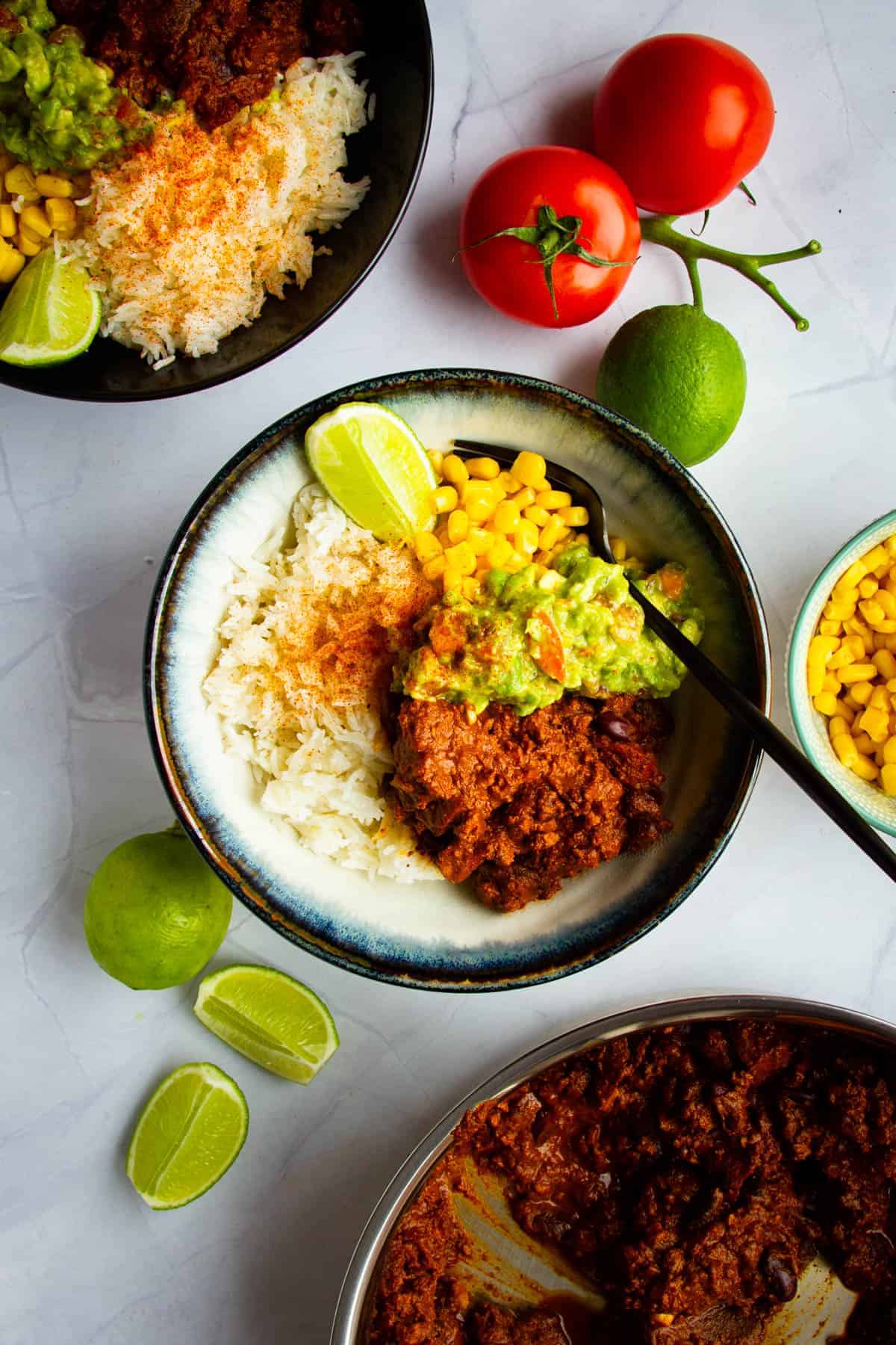 Sofritas in a bowl with guac, beans, corn and fresh lime.