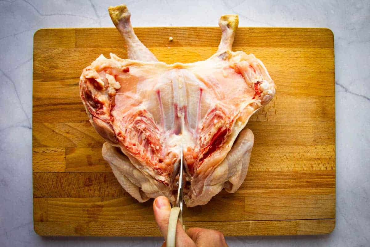 Cutting the breastbone of the whole chicken.