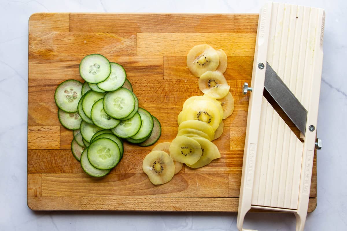 Slicing the cucumber and kiwi with the mandoline.